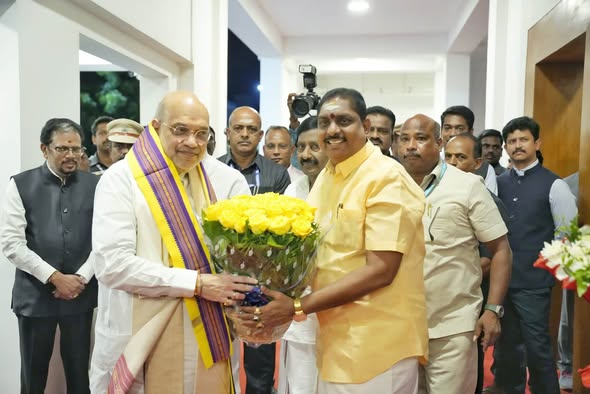 அமைச்சர் ஆ. நமச்சிவாயம் அமித் ஷாவுக்குப் பொன்னாடை அணிவித்து வரவேற்கிறார்